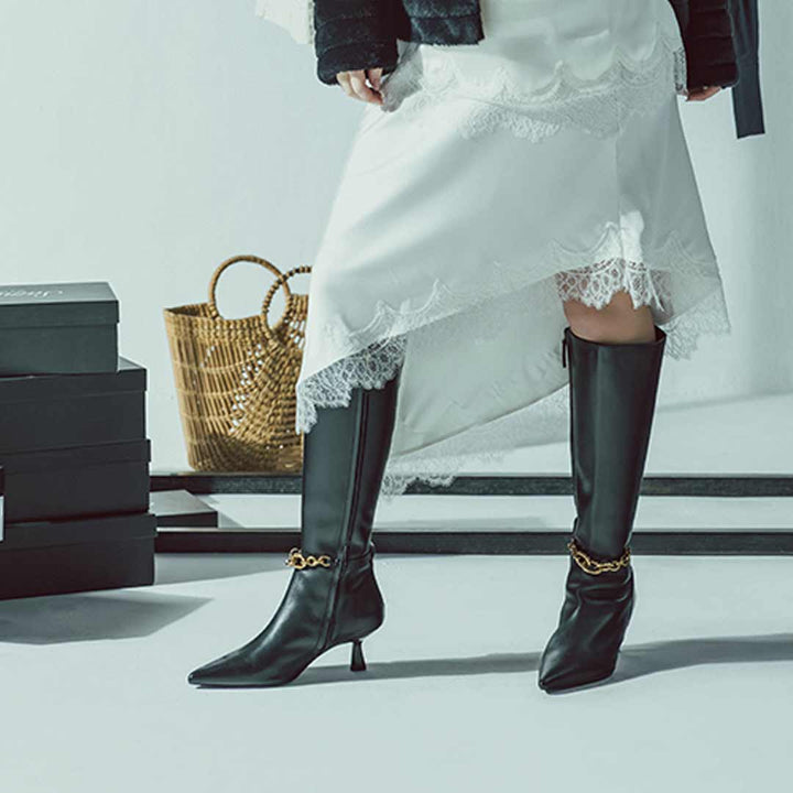 Women's black leather knee high boots by Saint Freya, styled with a lace dress, lifestyle view