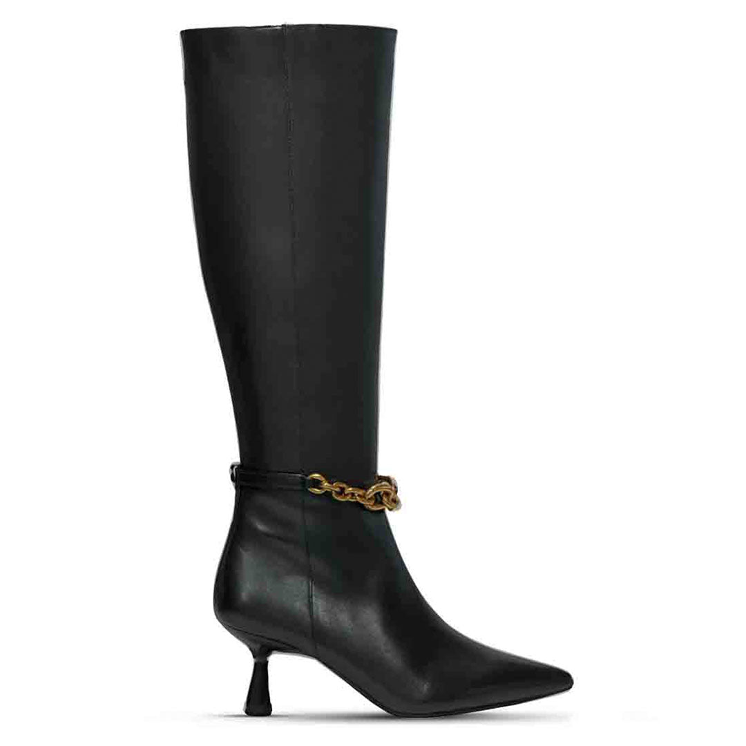 Saint Freya chain embellished black leather knee high boots for women, side view of gold chain ankle strap