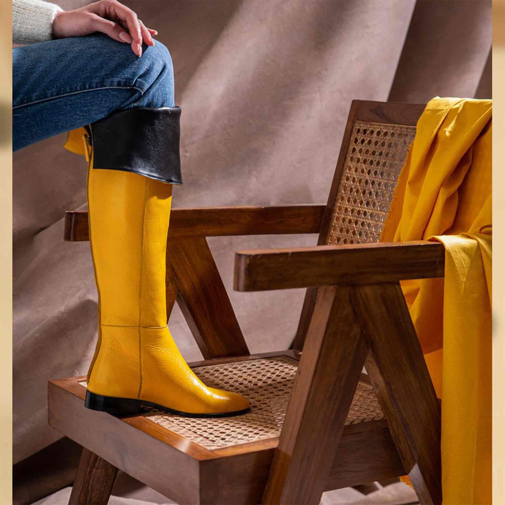 Women's yellow leather above the knee boots UK by Saint Grace, styled seated lifestyle shot