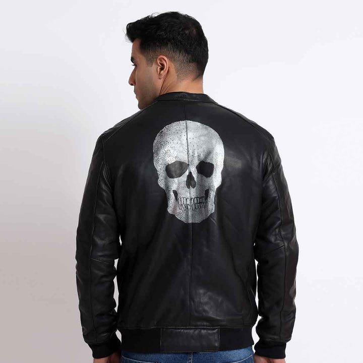 Back view of a black leather bomber jacket with a metallic skull print.