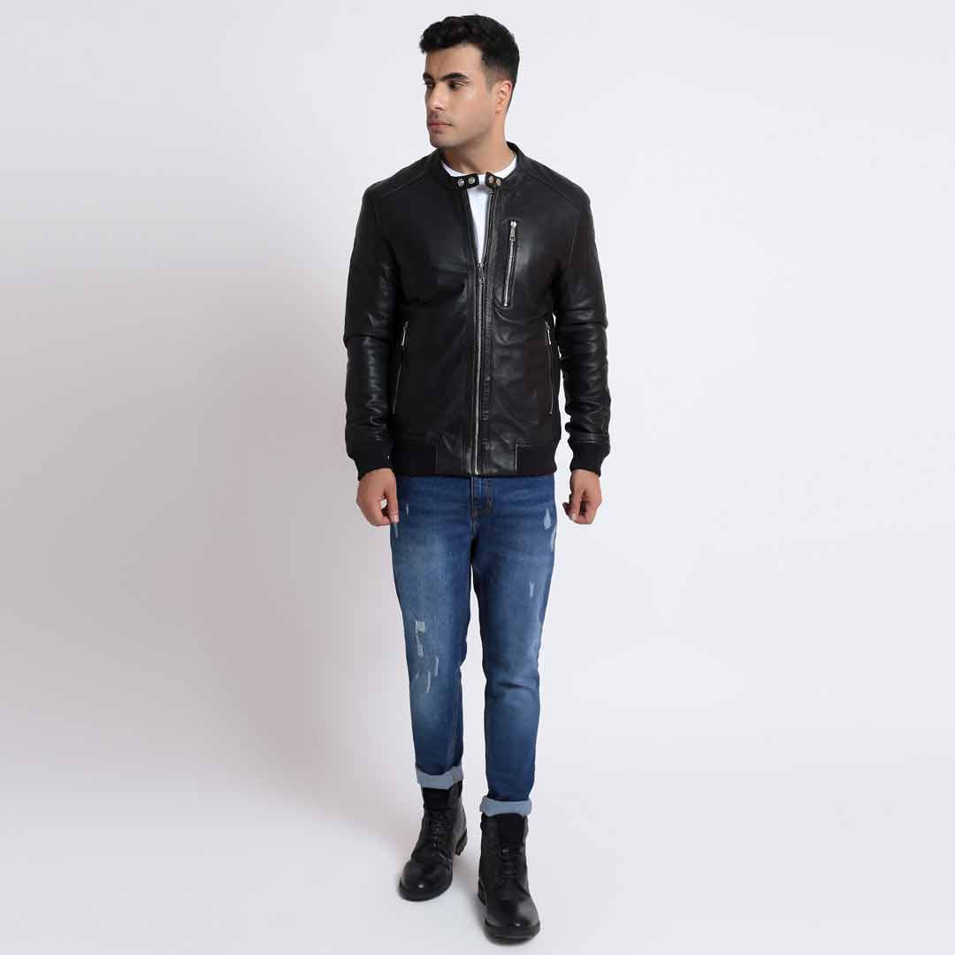 Full-length shot of a man wearing a black leather bomber jacket.
