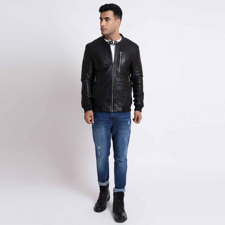 Full-length shot of a man wearing a black leather bomber jacket.