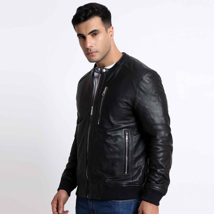 Side view of a man wearing a black leather bomber jacket.