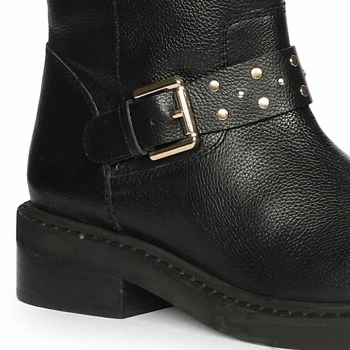 Close-up of studded harness buckle on Saint Harley black leather knee high boots