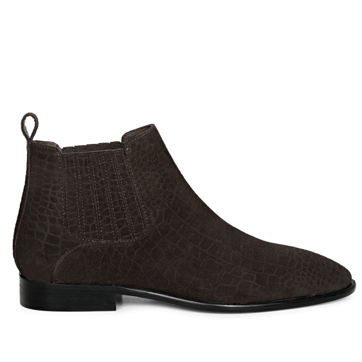 A brown crocodile print suede leather Chelsea boot with a slip-on closure, leather pull tab, and elasticated side panels.