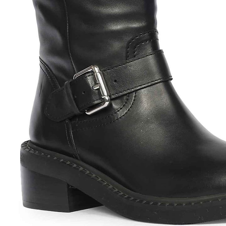 Close-up of ankle buckle strap on Saint Imogen multi studded black leather long boots