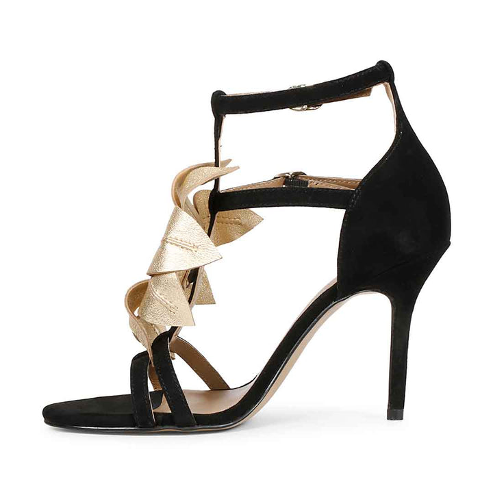Saint Lilly gold flower embellished black leather stilettos with ankle strap detail, left view