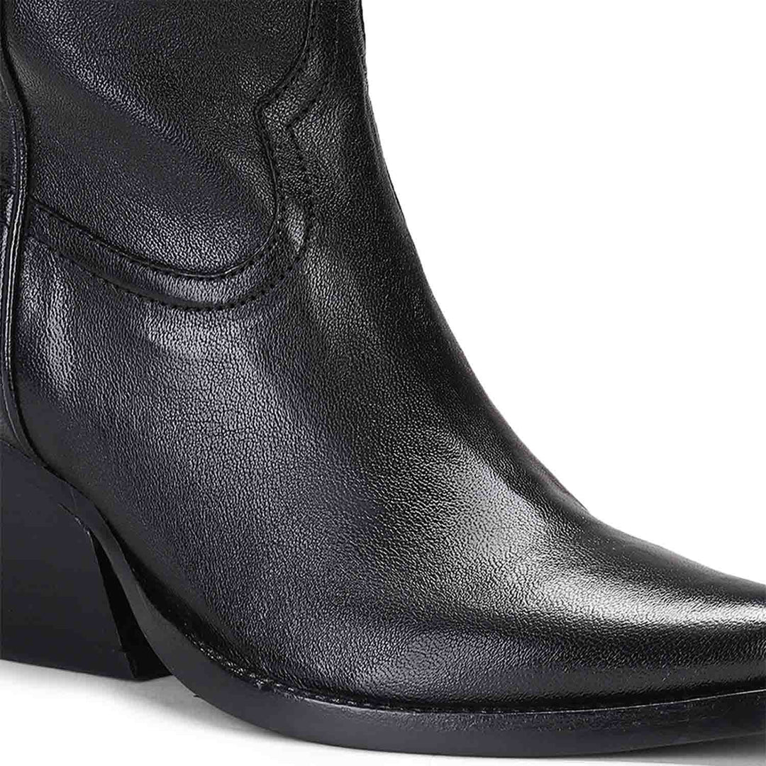 Close-up of angled block heel on Saint Loanna black leather knee high boots