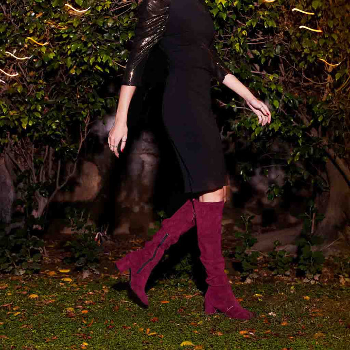 Women's maroon suede thigh high boots UK by Saint Luisa, styled night-time walking lifestyle shot