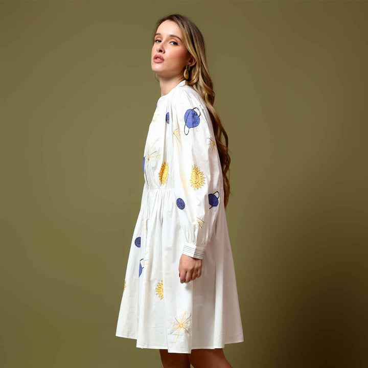 Close-up of the celestial star and sun print on a white cotton dress.