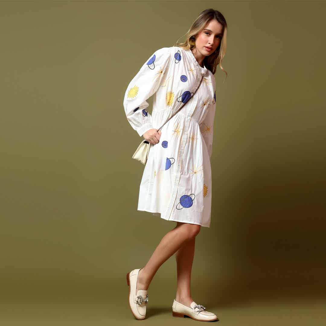 Side view of a woman wearing a white printed cotton poplin dress.