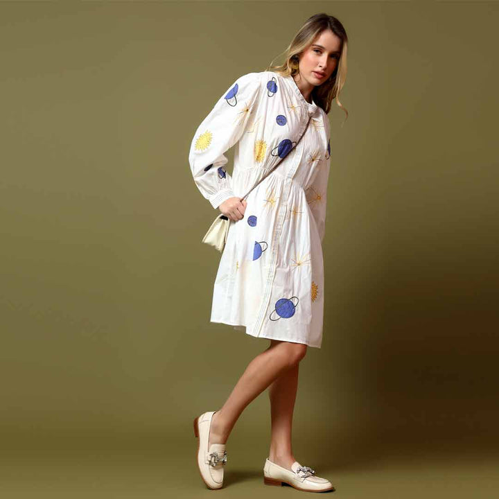 Side view of a woman wearing a white printed cotton poplin dress.