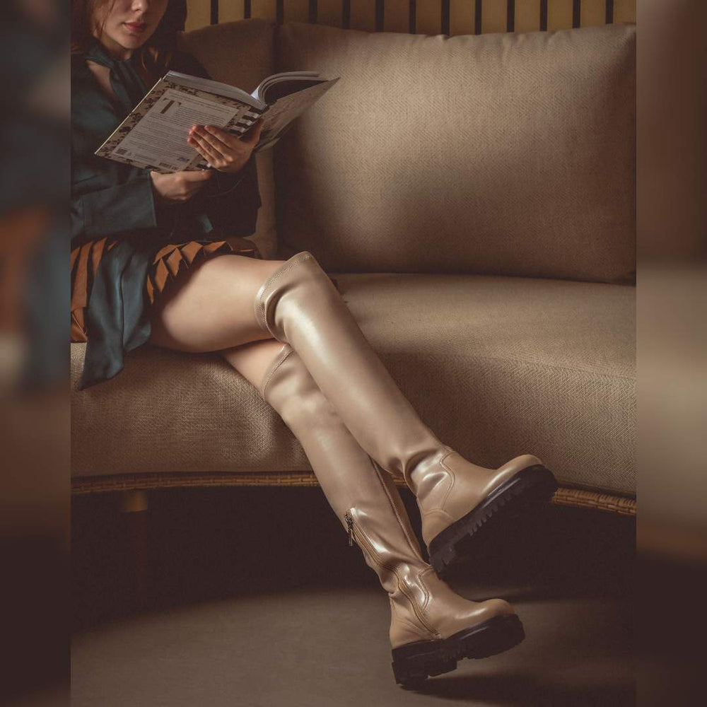 Women's taupe thigh high boots by Saint Malia, styled seated lifestyle shot