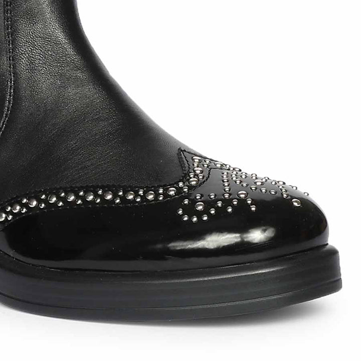 Close-up of crystal-studded patent toe cap on Saint Marcelline black leather knee high boots