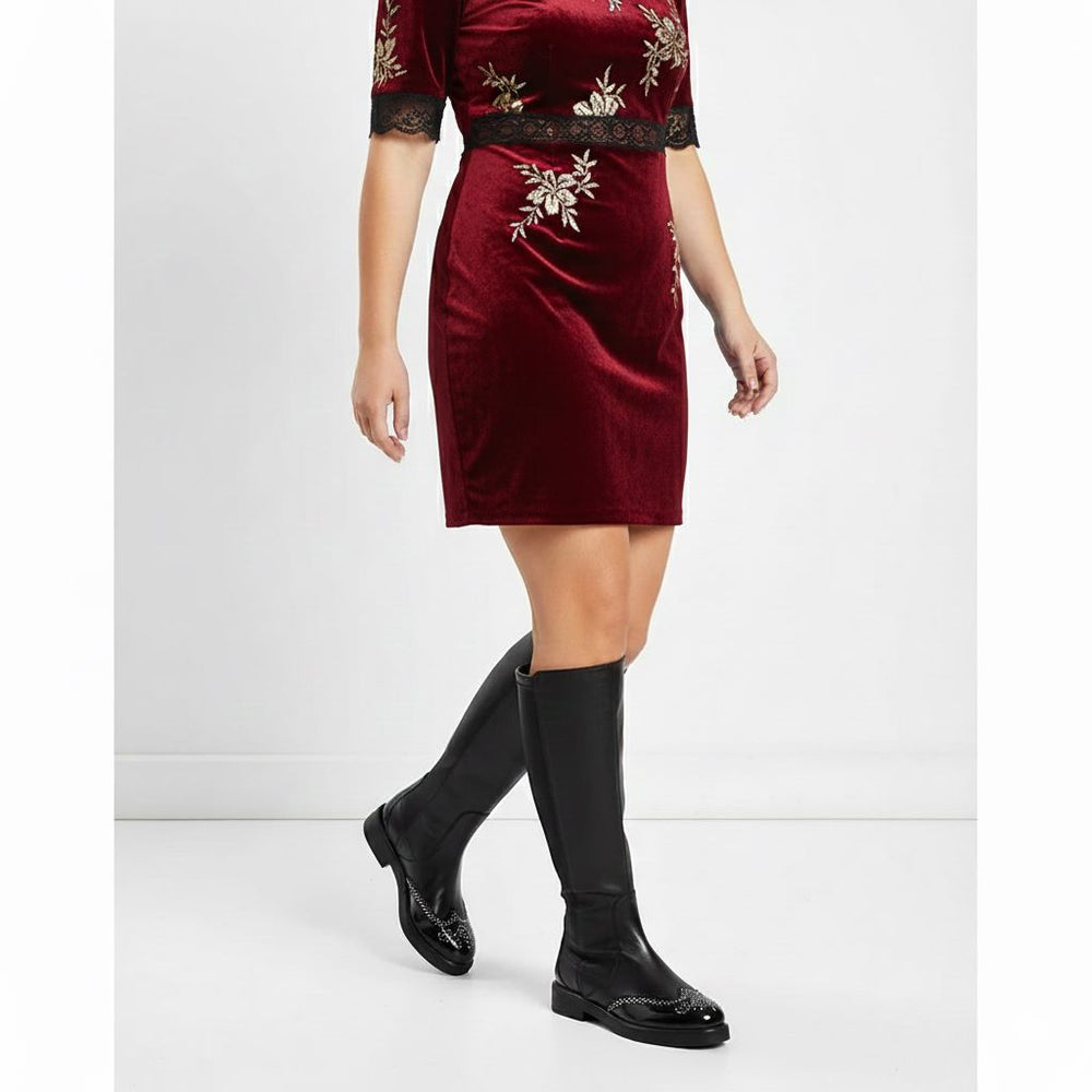 Women's black leather knee high boots by Saint Marcelline, styled with a velvet dress, lifestyle view