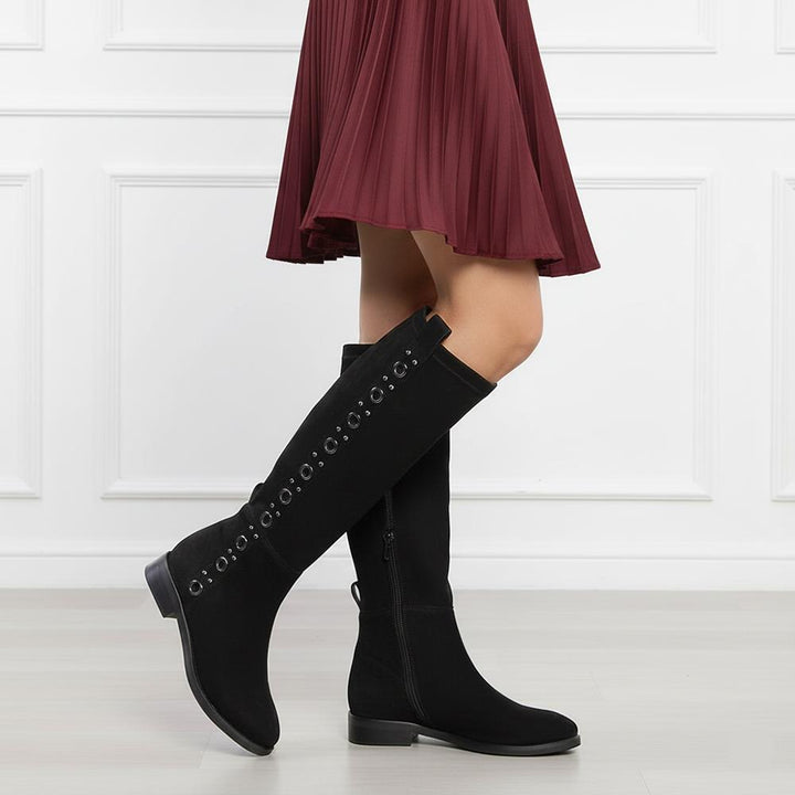 Women's Saint Marlowe black suede long boots styled with a pleated maroon skirt, lifestyle view