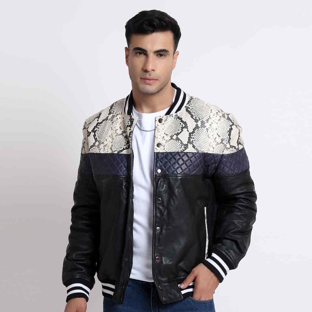 Man wearing a colourblock bomber jacket with a python-print yoke, navy quilted panel, and black leather body.