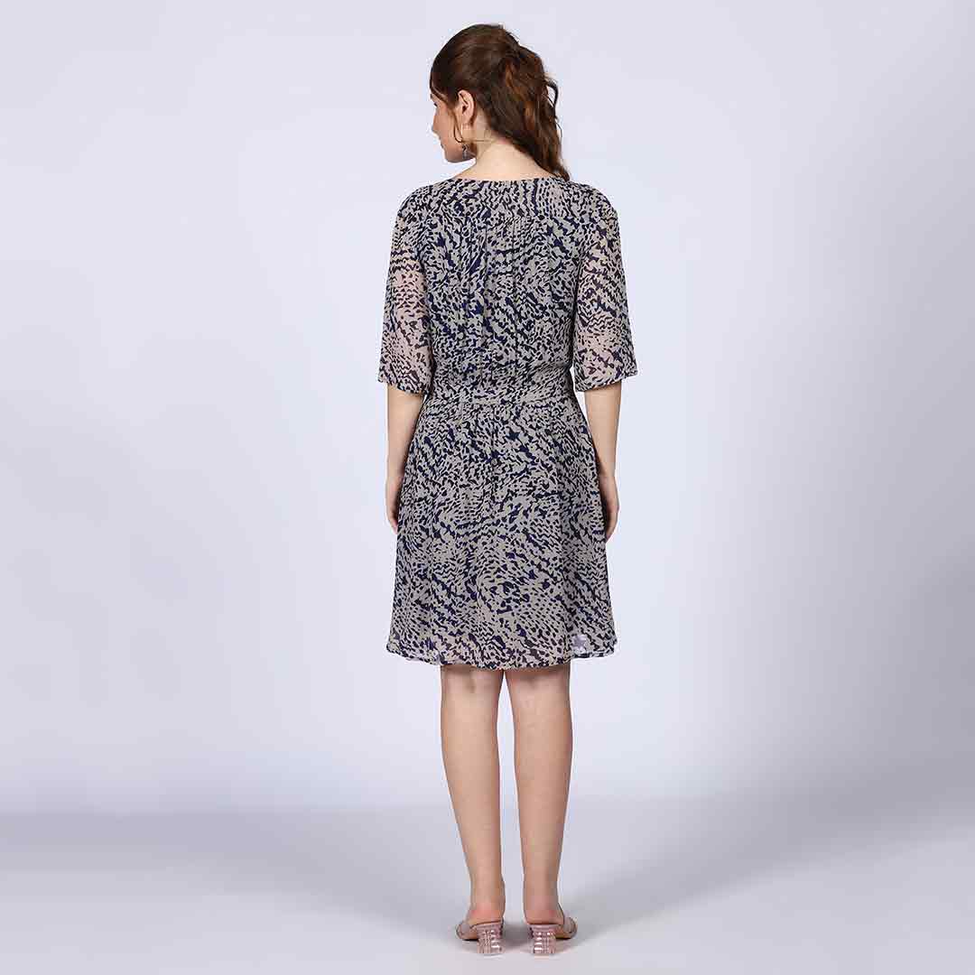 Women's navy abstract print mini dress by Saint, seated lifestyle view.