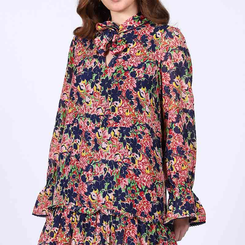 Close-up of tie neck and bell cuff on Saint Nerina blue multi bloom mini dress for women UK.