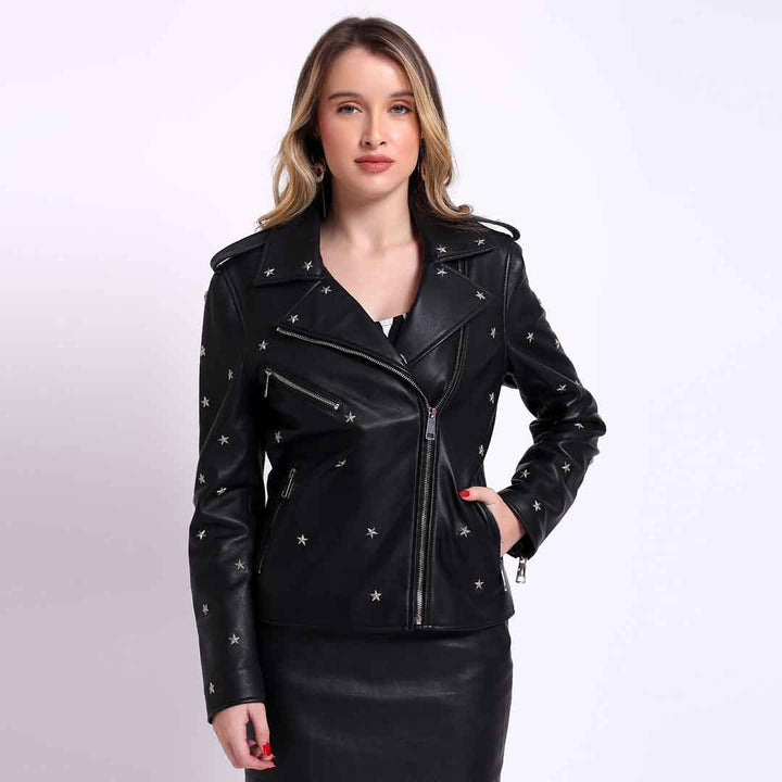 A woman wearing a black leather jacket with star embellishments, a snap collar, and zipper cuffs. The jacket is styled with a button and zipper closure, and she has two zipper pockets on the outside.