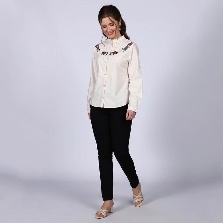 Women's off-white floral embroidered cotton top for women UK, front view styled with black trousers.