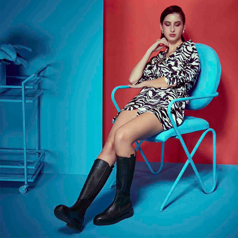 Women's black leather knee high boots by Saint Pietro, dramatic editorial lifestyle shot