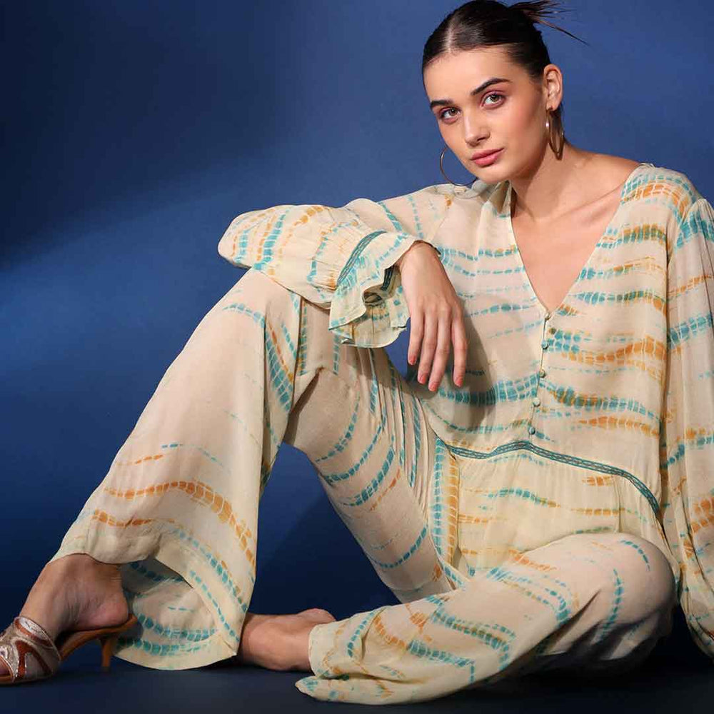 Women's multicolour tie-dye crepe co-ord set by Saint Priscilla, seated lifestyle view.