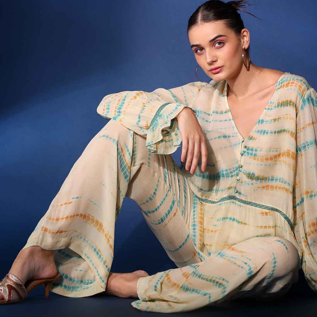 Women's multicolour tie-dye crepe co-ord set by Saint Priscilla, seated lifestyle view.