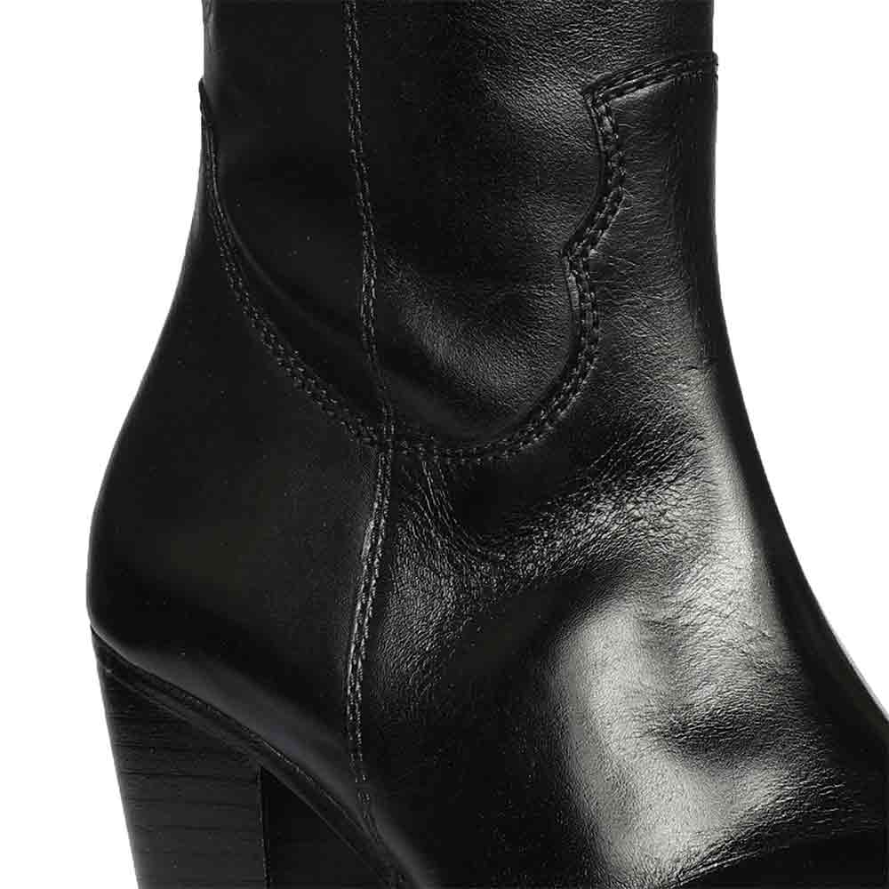 Close-up of stacked heel and western-cut shaft on Saint Prune black leather knee high boots