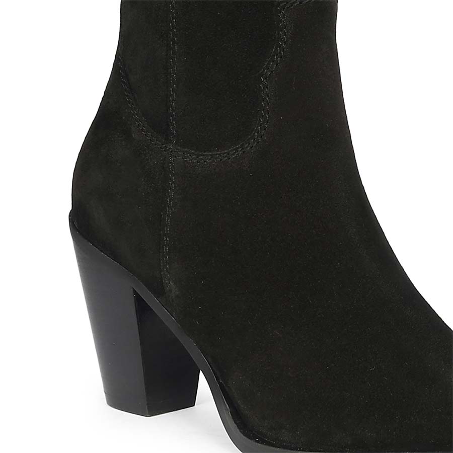 Close-up of stacked heel and western-cut shaft on Saint Prune black suede knee high boots