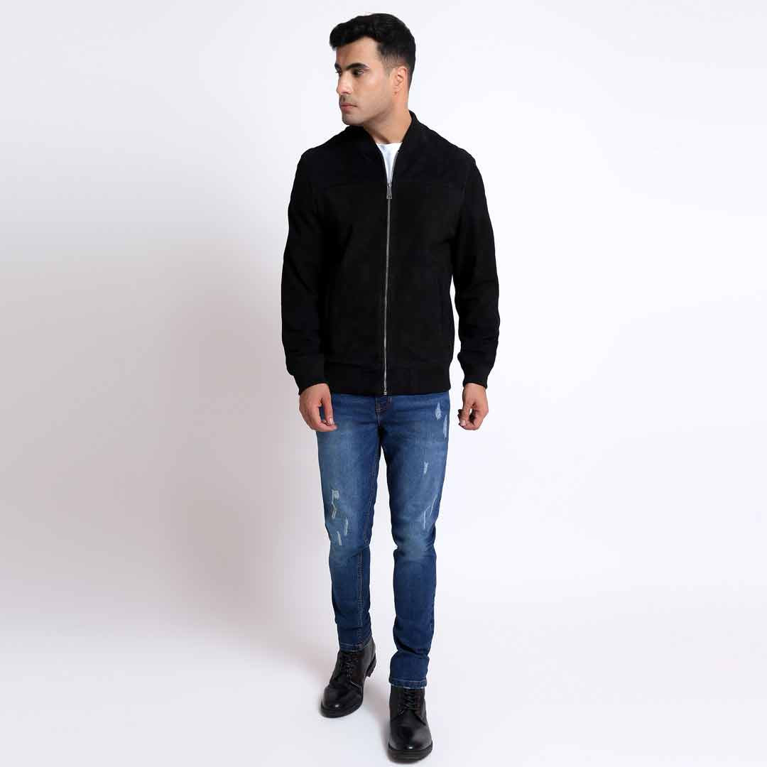 Full-length shot of a man wearing a black bomber jacket.