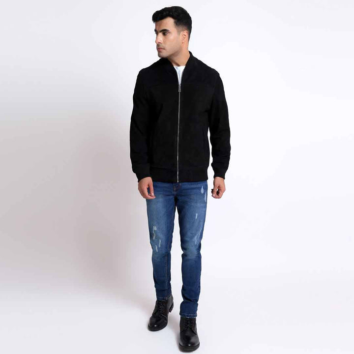 Full-length shot of a man wearing a black bomber jacket.