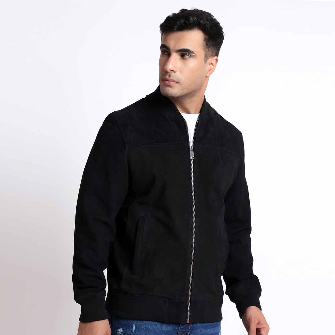 Side view of a man wearing a black bomber jacket.