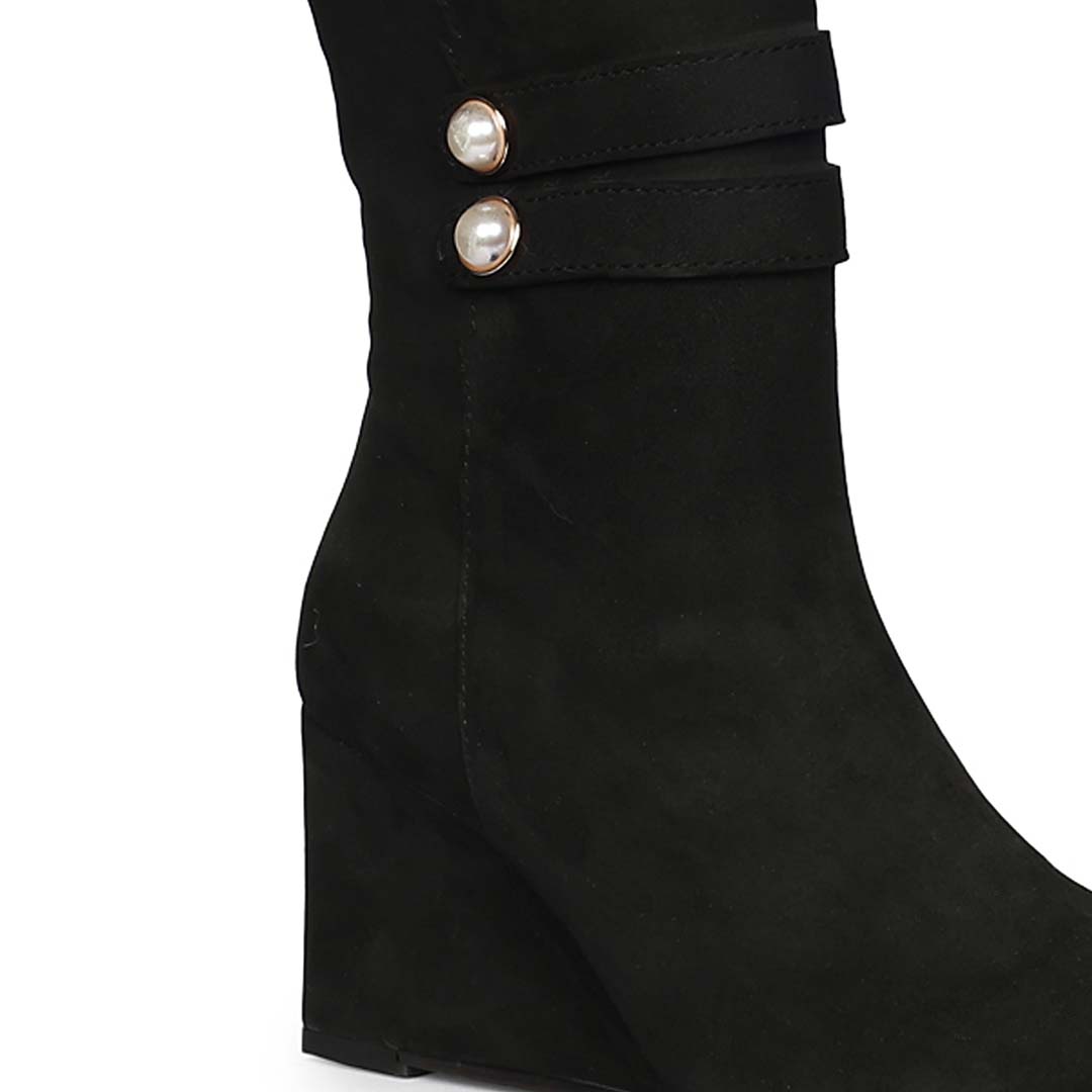 Close-up of pearl-button strap on Saint Rosabel black suede wedge knee high boots