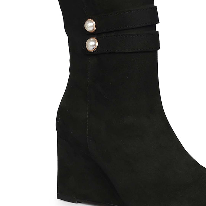 Close-up of pearl-button strap on Saint Rosabel black suede wedge knee high boots