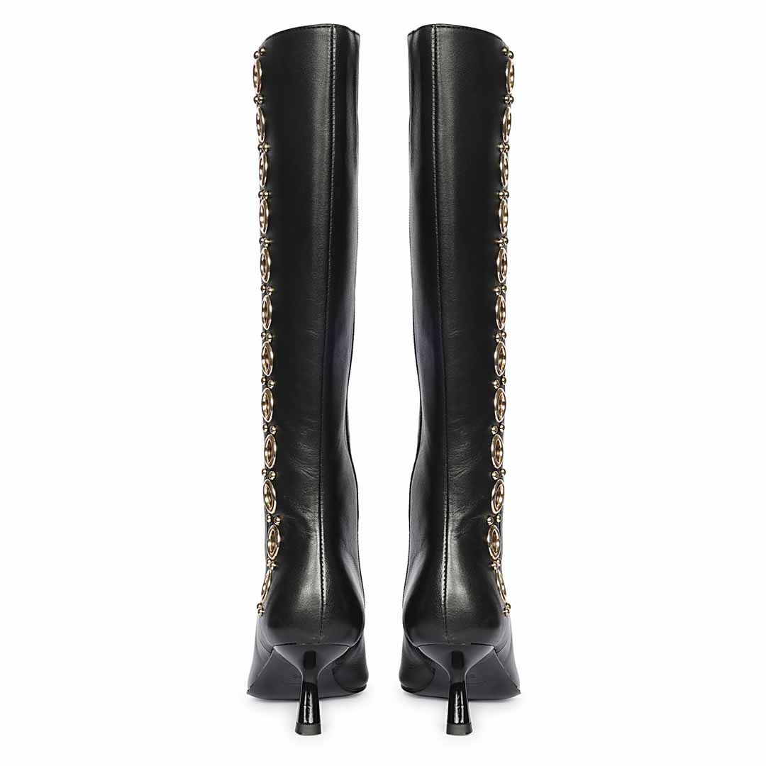 Women's black leather knee high boots, back pair view showing gold eyelet trim