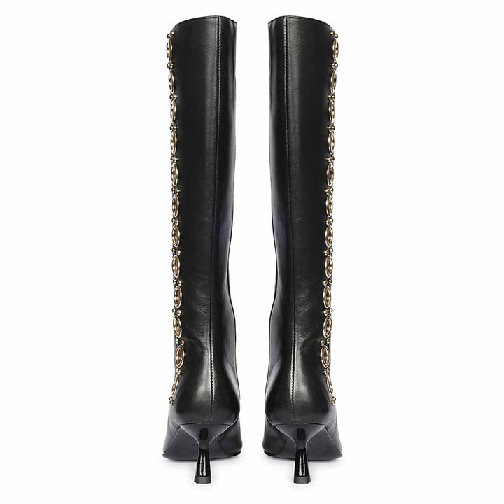Women's black leather knee high boots, back pair view showing gold eyelet trim