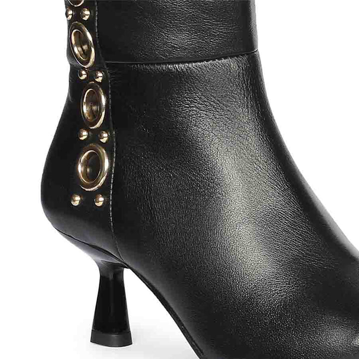 Close-up of gold eyelet trim on Saint Sadie black leather knee high boots