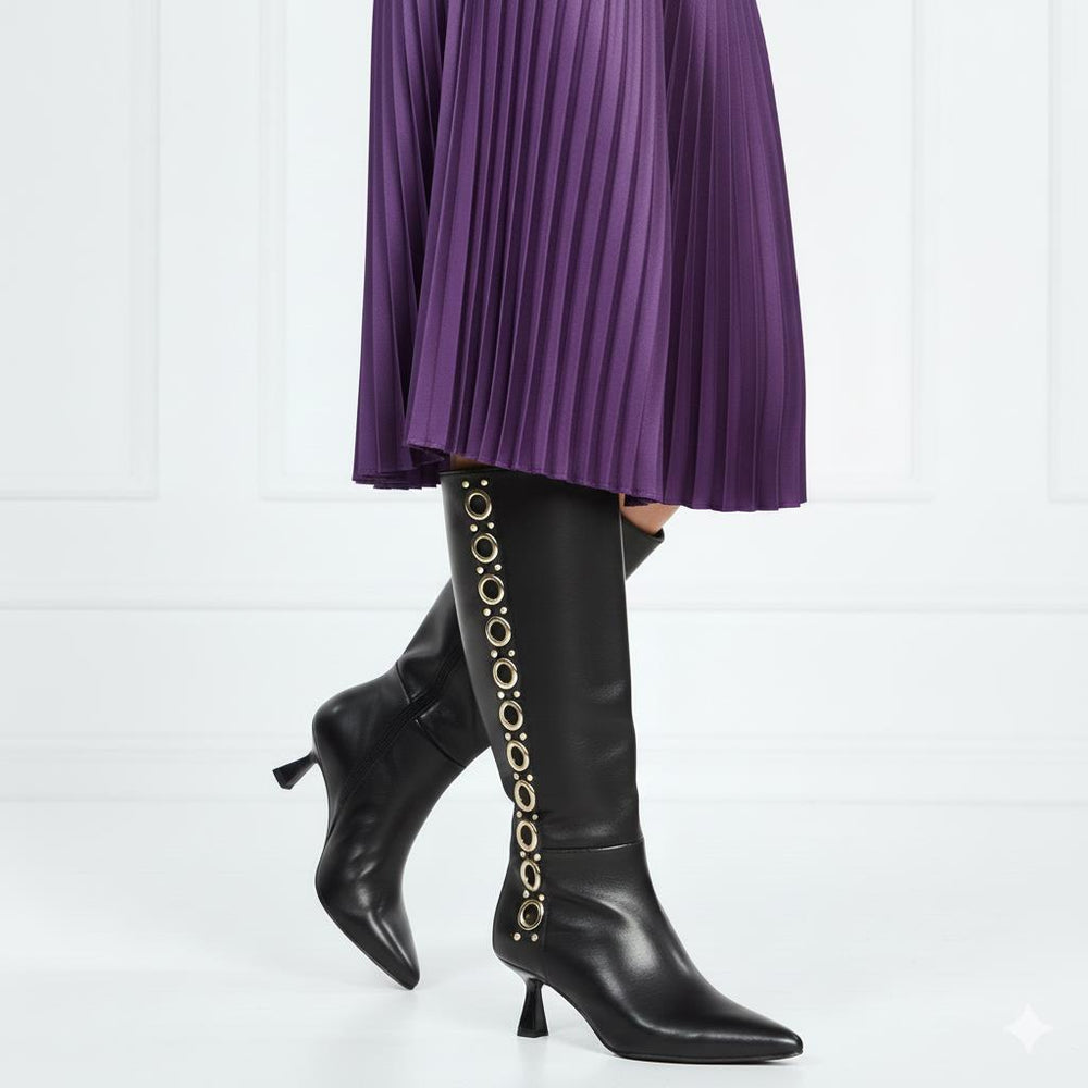 Women's black leather knee high boots by Saint Sadie, styled with a pleated skirt, lifestyle view