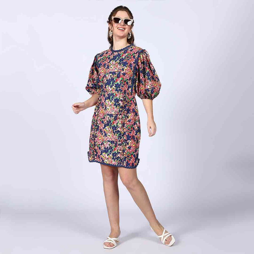 Women's multicolour floral short dress by Saint Solene, front view styled with sunglasses.