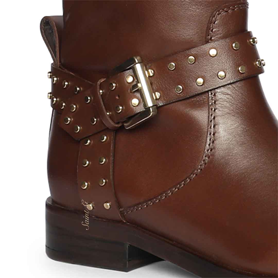 Close-up of gold studded buckle strap on Saint Soraya brown leather long boots