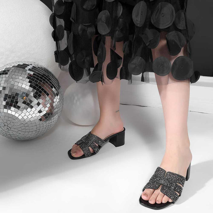 Black low block heel shoes crystal embellishment sole detail – close-up
