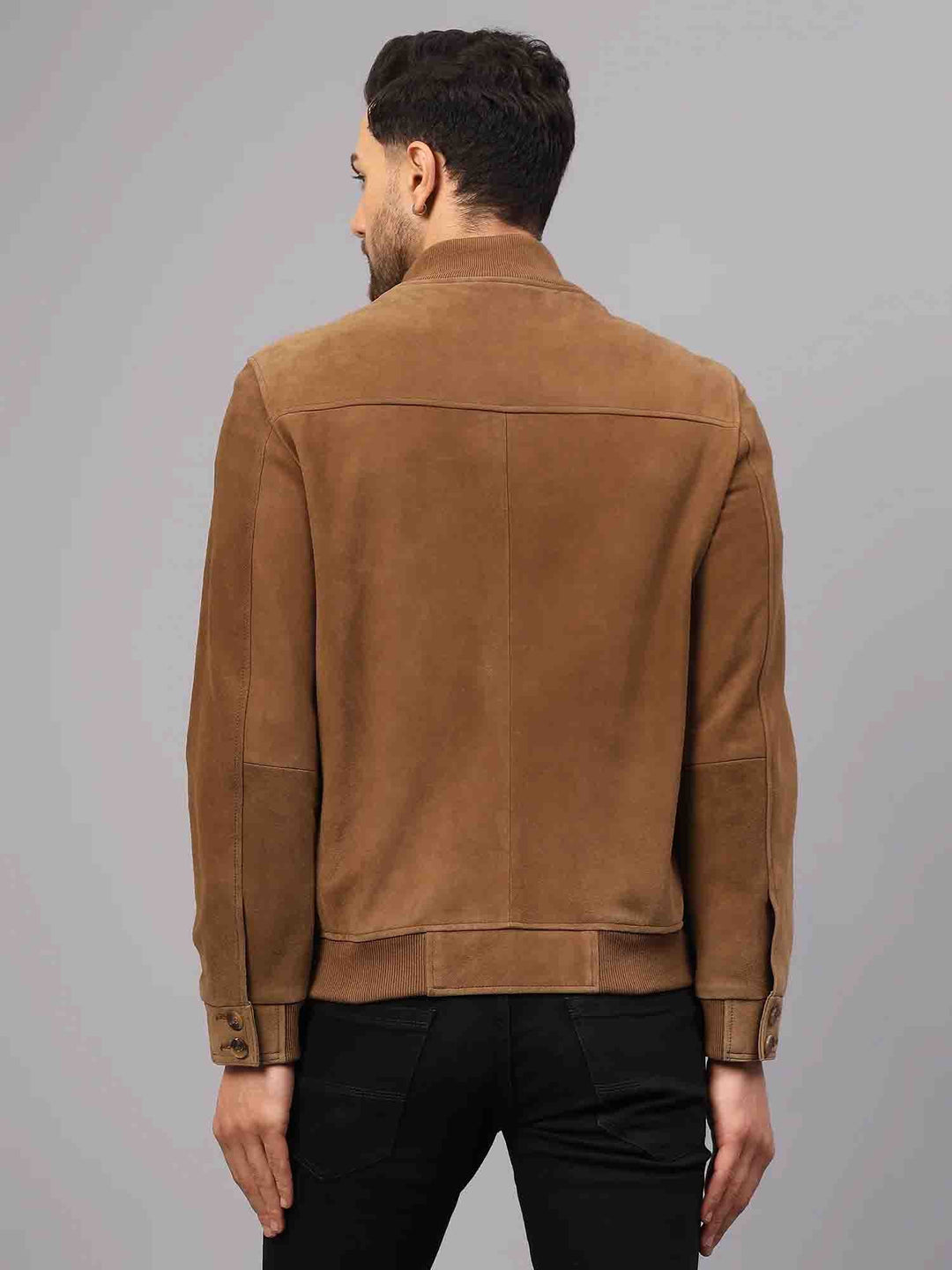 Back view of a tan suede jacket showing the ribbed cuffs and hem.