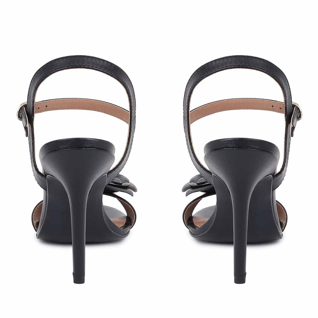 Saint Veronique flower embellished black leather stilettos, back view