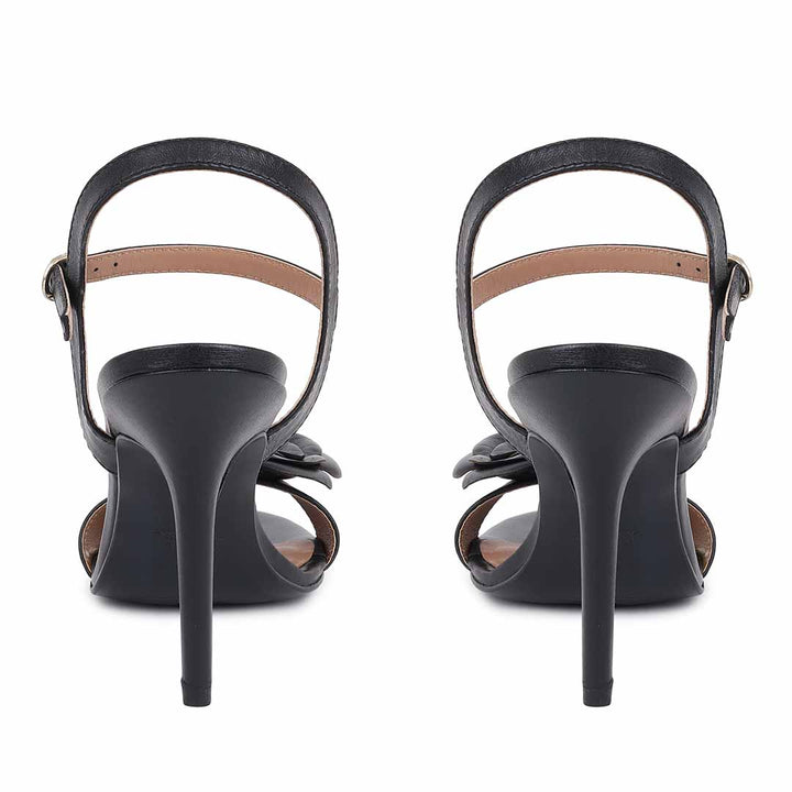 Saint Veronique flower embellished black leather stilettos, back view