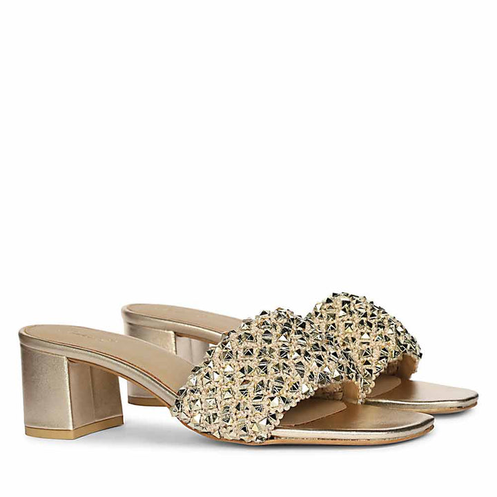 Gold low block heel sandals with embellishments on a white background