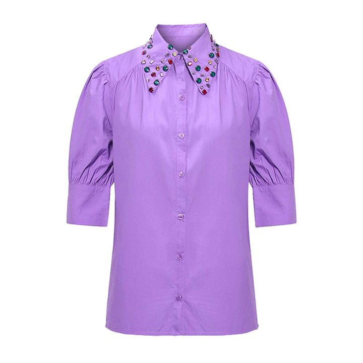 Close-up of jewelled embellishment on a purple shirt collar  for UK Women