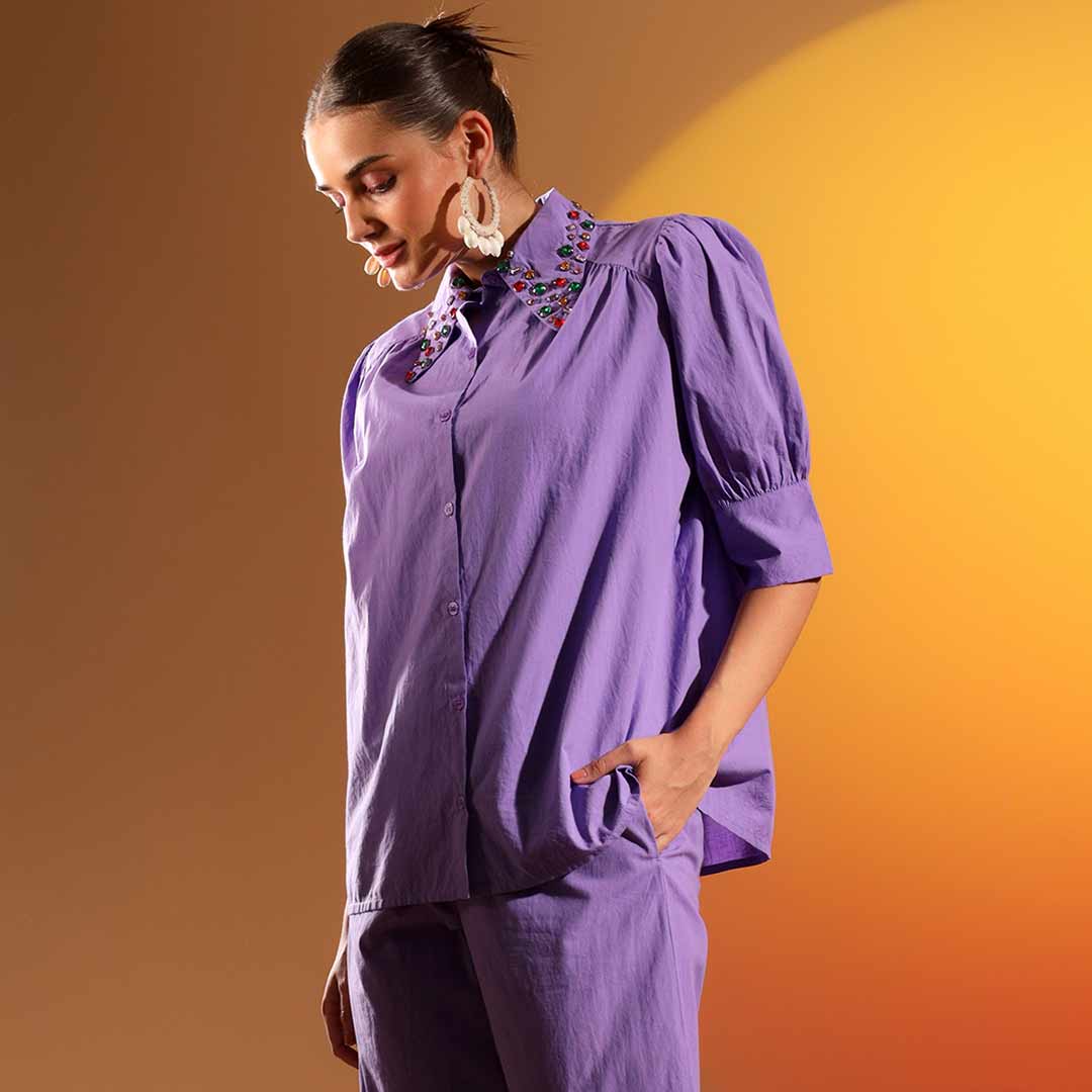 Side view of a woman wearing a purple embellished cotton shirt.