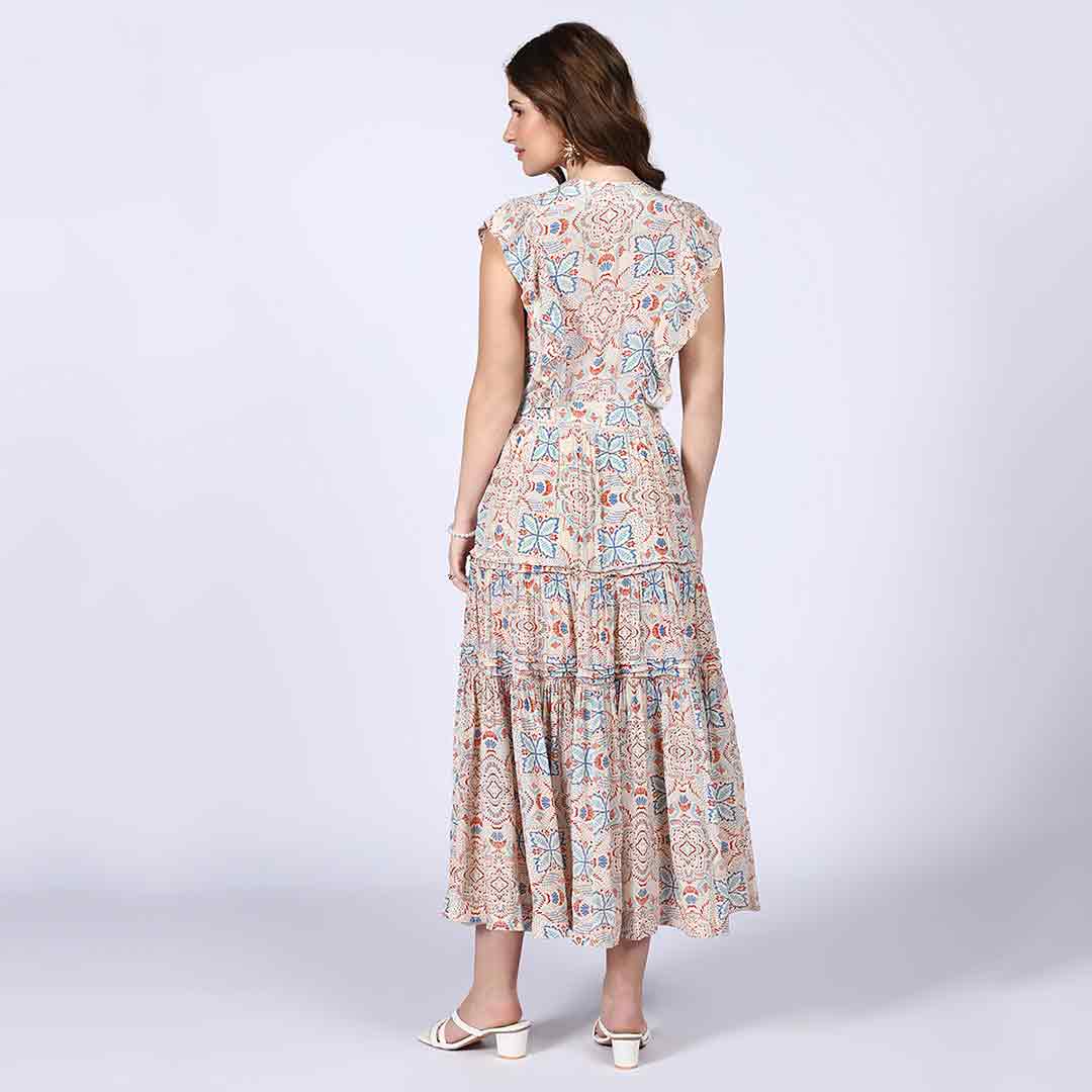 Back view of a woman wearing a beige printed tiered maxi dress.
