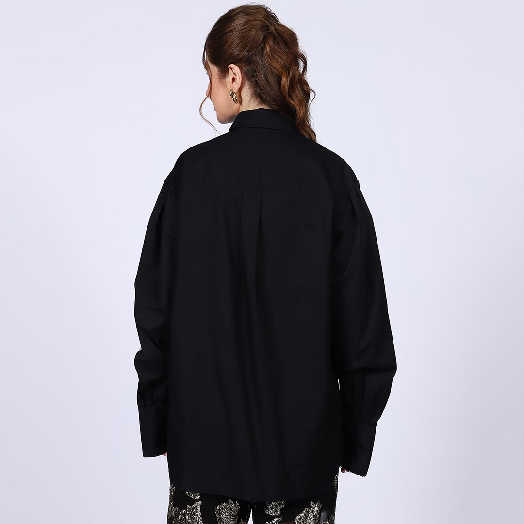 Back view of a woman wearing a black cotton rhinestone-embellished shirt.
